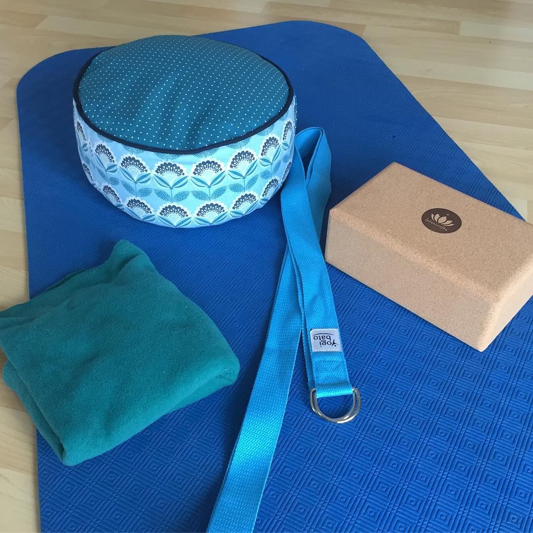 A yoga mat, yoga block, and a yoga strap